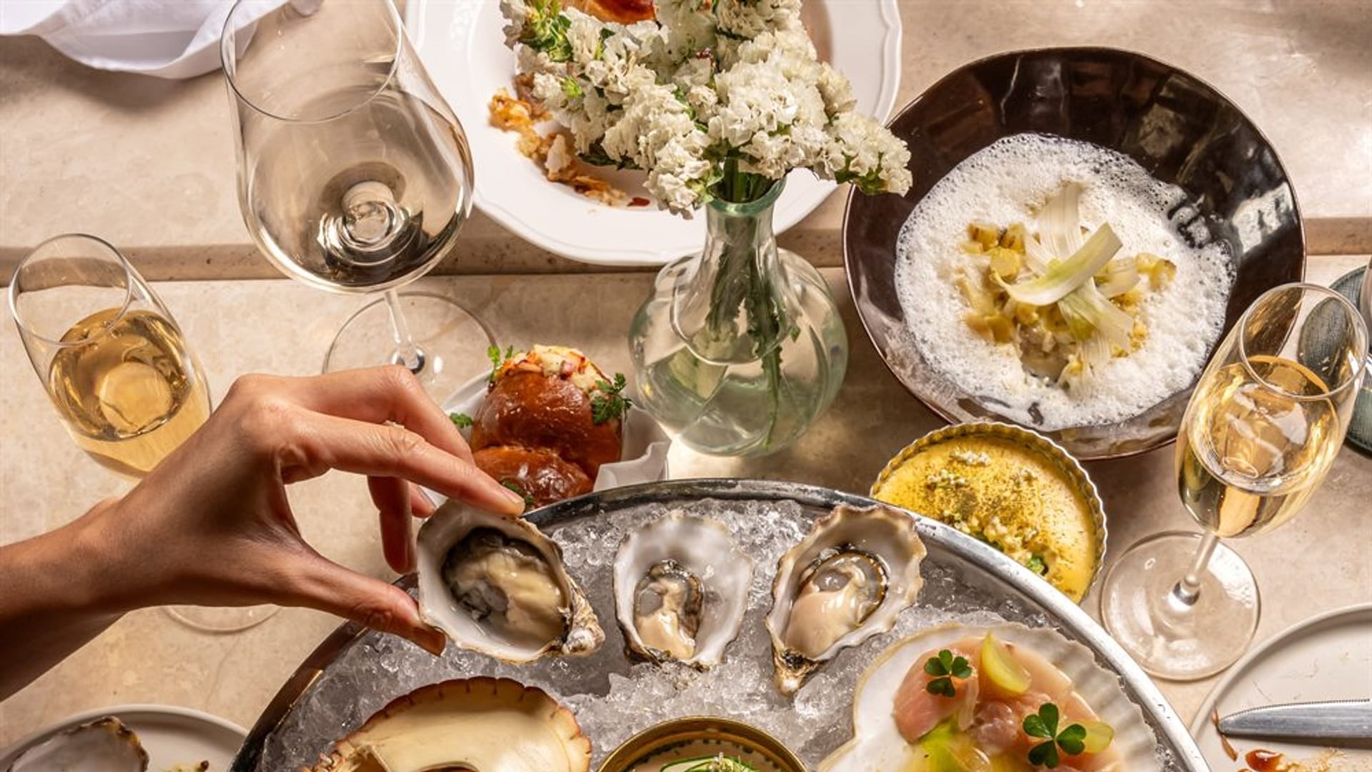 A dinner table set at Bisou, a modern French restaurant on Soi Langsuan in Bangkok, with the sharing menu laid out