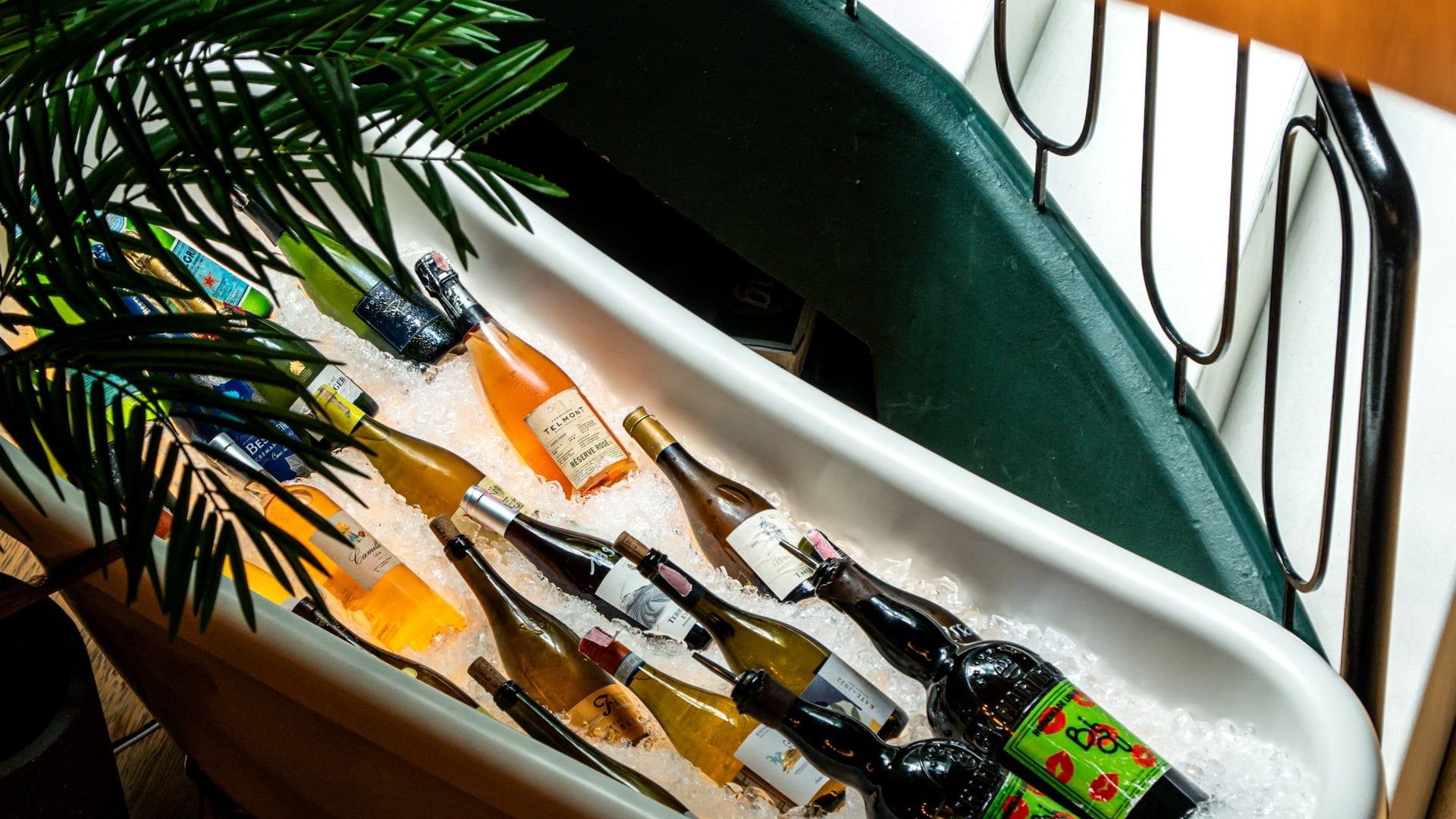 Wine bottles on ice in the white bathtub under the spiral staircase at Bisou, a modern French restaurant on Soi Langsuan in Bangkok
