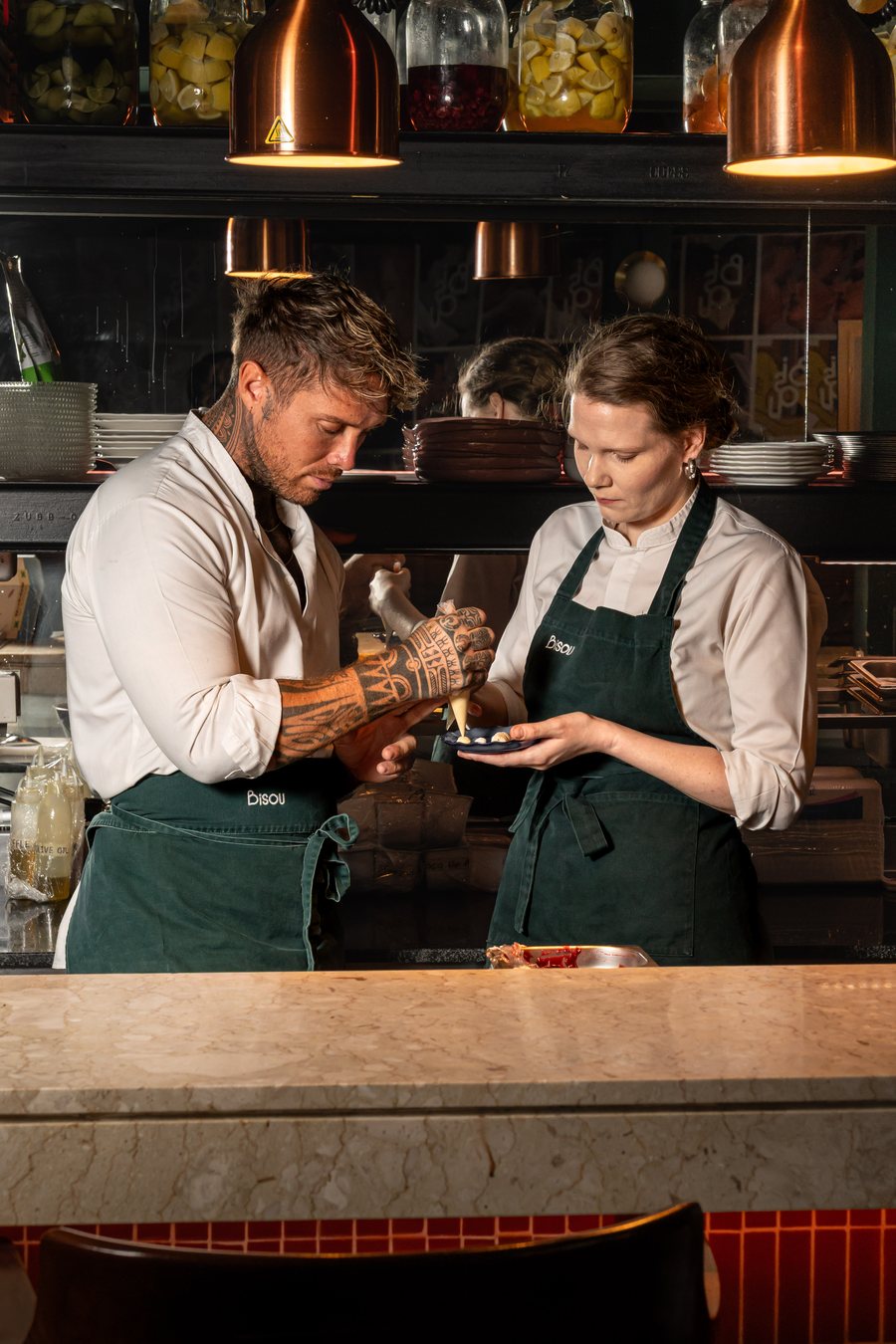 Chef Antoine and Chef Freya plating at the Bisou kitchen pass